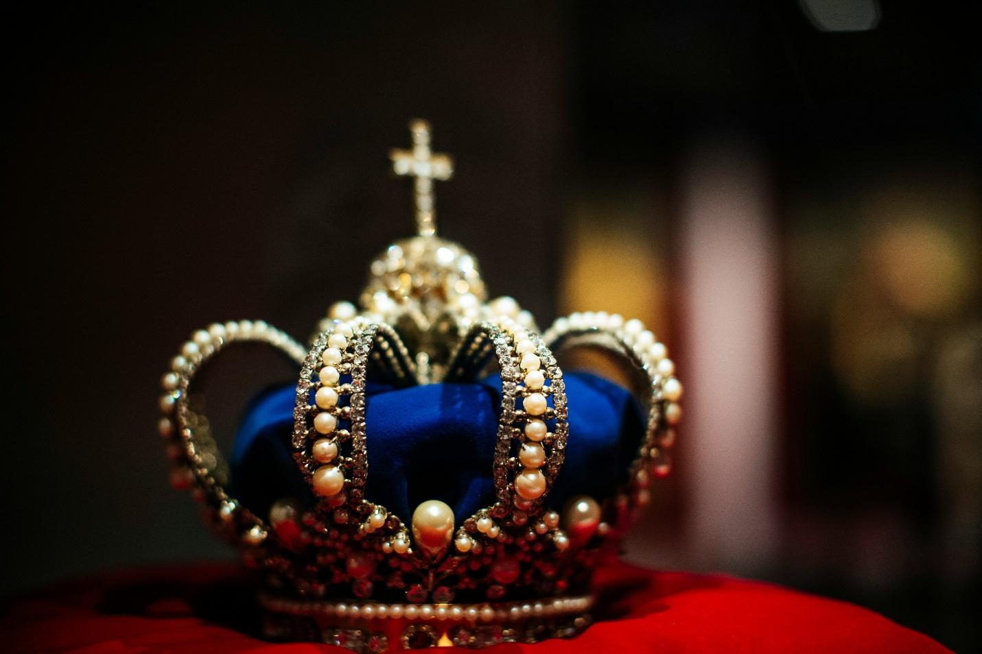 A crown with a cross on itDescription automatically generated
