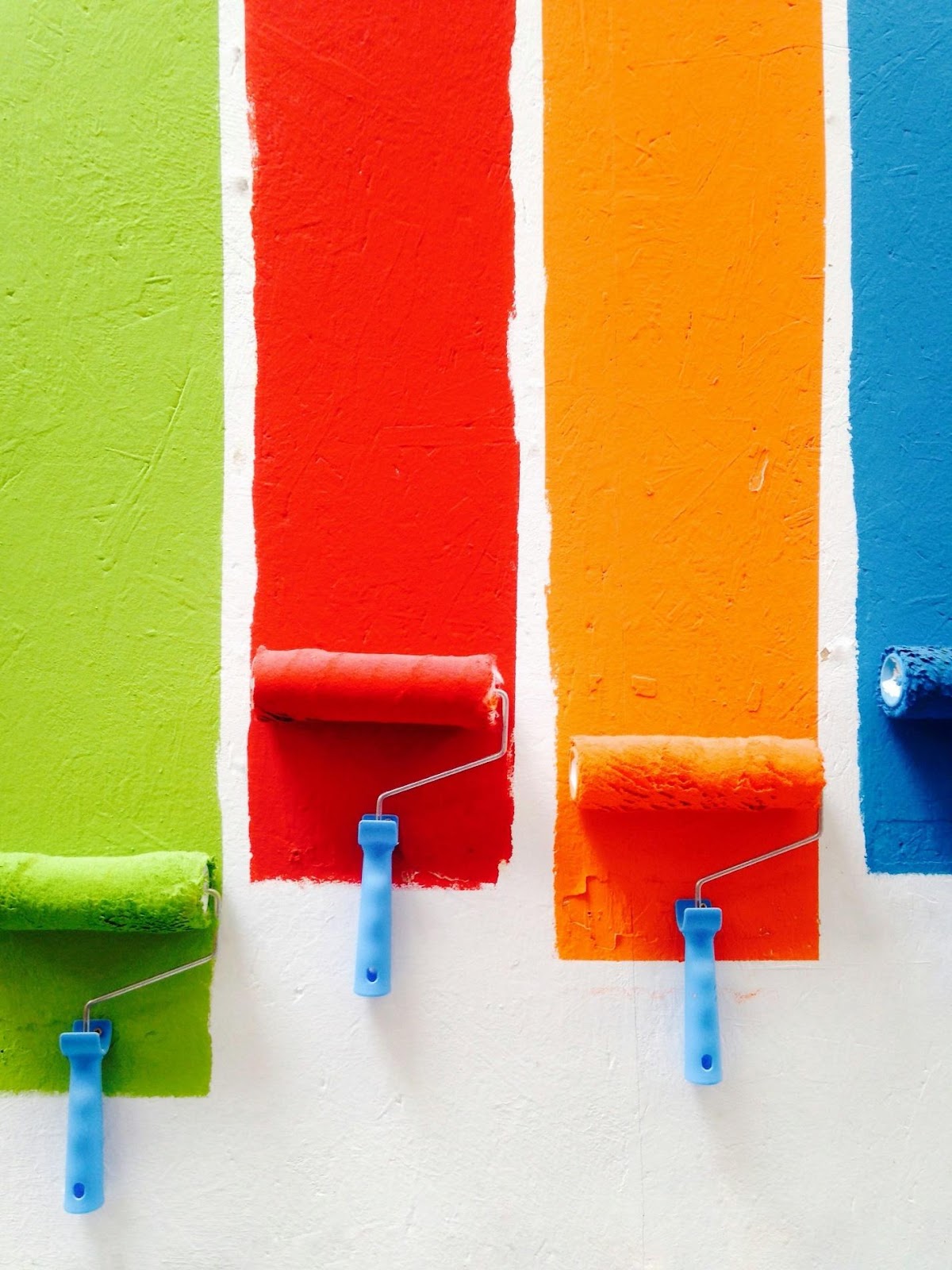 A row of paint rollers on a wallDescription automatically generated