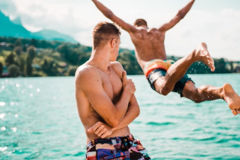 Man watching another man diving into water